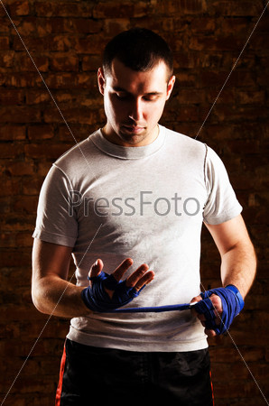 mma fighter is getting ready against brick wall