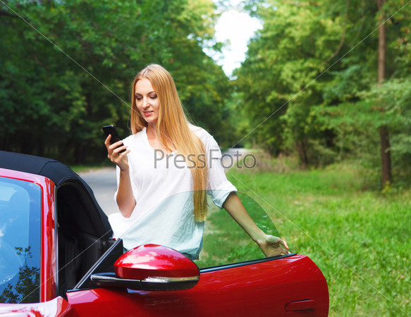 Beautiful blond young woman in a sports car