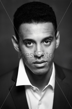 Black and white image of calm businessman looking at camera