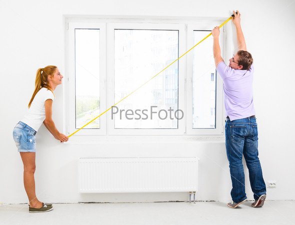 Couple Is Measuring Their New Empty Apartment