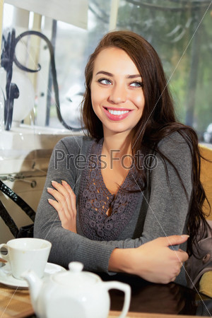 Young smiling lady sitting in the restaurant