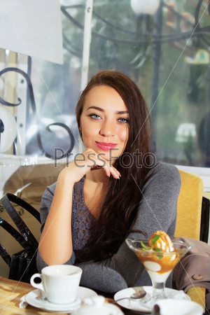 Young smiling woman posing in a cozy cafe