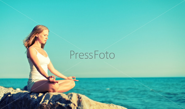 woman meditating in  lotus yoga on  coast of  sea on the beach
