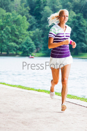 Молодая и красивая женщина бегает в парке