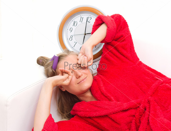 sleepy woman with a clock yawning over white background