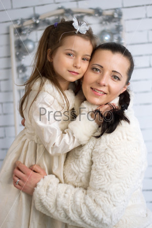 Mom and daughter in the winter dresses