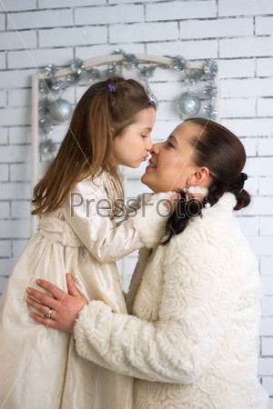 Mom and daughter in the winter holidays New Year and Christmas dresses