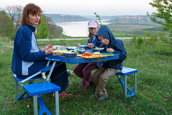 Family have the dinner on evening spring bank of Dnister river ( Bakota - is a historic submerged settlement, Khmelnytskyi Oblast, Ukraine)