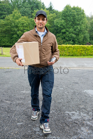 Delivery guy bringing a cash on delivery parcel with online purchases to the door, with a wireless cash machine in his hand