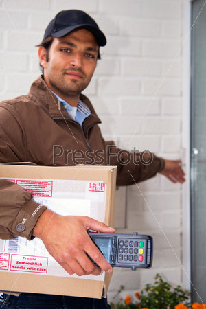 Postal worker, carrying a parcel and a portable ATM rings a doorbell with a cash on delivery service