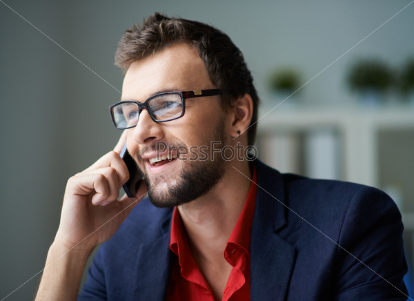 Handsome businessman in smart casual and eyeglasses speaking on the phone
