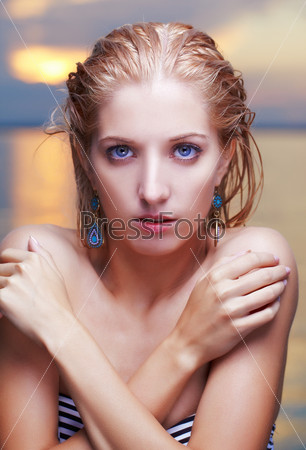 portrait of young beautiful blue-eyed blonde woman. sea on background