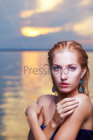 portrait of young beautiful blue-eyed blonde woman posing in ocean waters