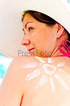 girl in hat on the beach protects the skin from the sun