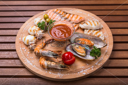snack from seafood - grilled fish, cuttlefish, shrimp, mussel on wood