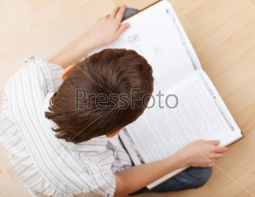 Child reading book on the floor at home