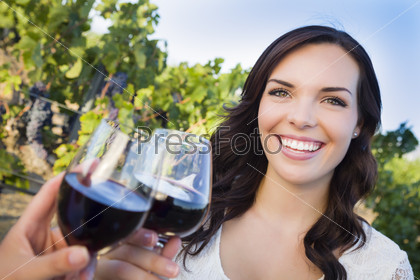 Молодая женщина наслаждается прогулкой и вином на винограднике