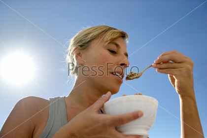 Woman eating cereal outside