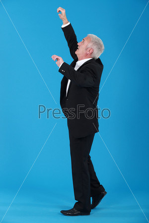 Senior businessman reaching upwards