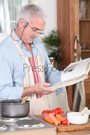 senior citizen cooking with recipe book