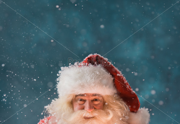 Magical portrait of Santa Claus in snowfall at North Pole. Lots of copyspace