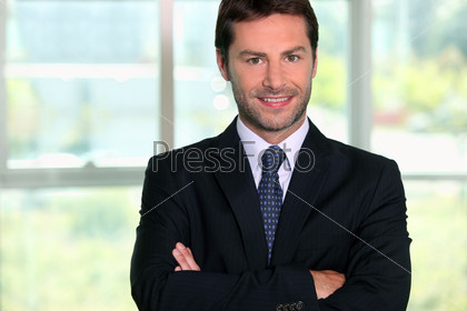 Businessman standing in front of a window, stock photo