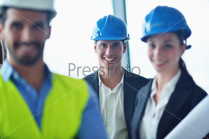 business people group on meeting and presentation  in bright modern office with construction engineer architect and worker looking building model and blueprint planbleprint plans