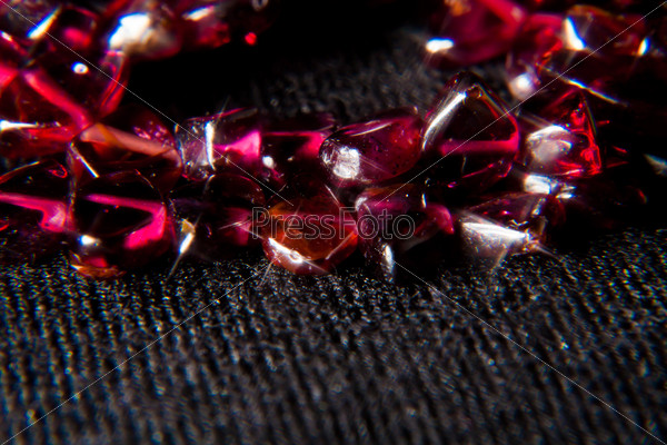 beads from garnet stone on dark background with star filter