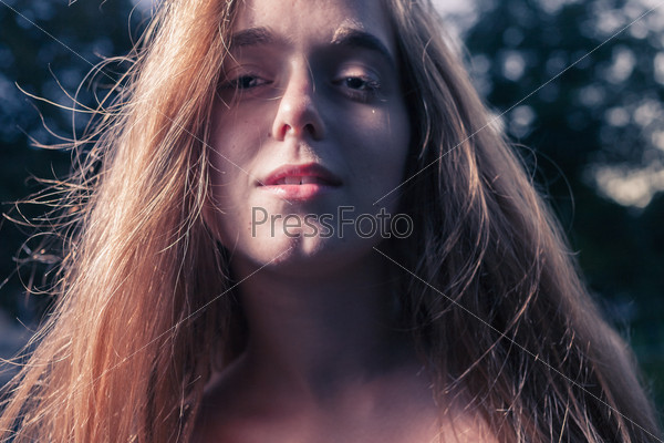 Sad 20s female outside very closeup shot. Portrait of a beautiful girl in the park in autumn season.