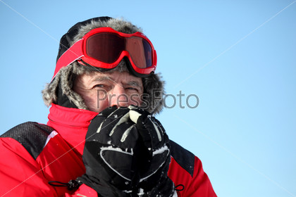 Portrait of a senior man with a ski mask in snow