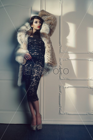 Fashion photo of beautiful young lady in a luxurious fur coat