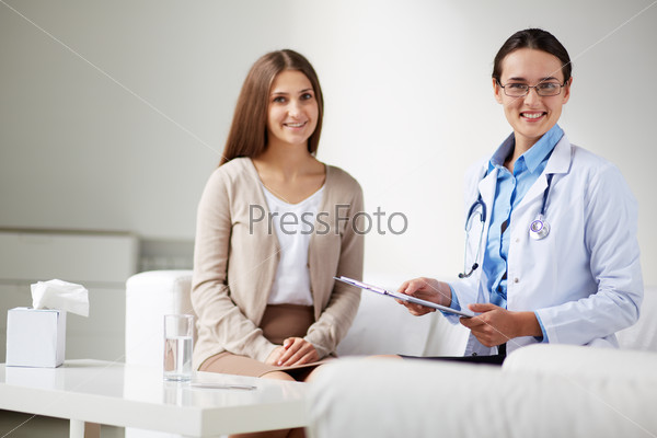 Female psychiatrist looking at camera on background of her patient