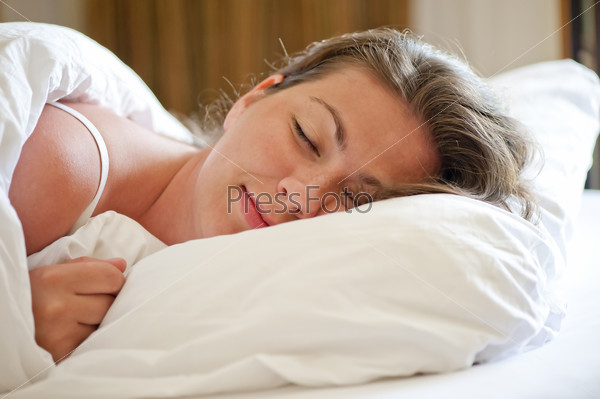 woman sleeps on a snow-white bed in the morning