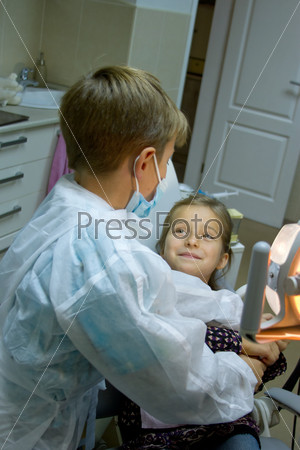 A couple of kids playing doctor at the dentist, stock photo