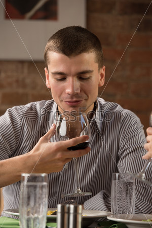 Man having fun at restaurant while drinking red wine and chatting with friends