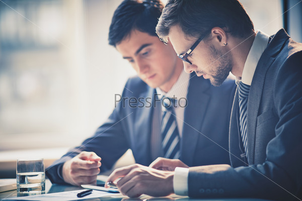 Image Of Two Young Businessmen Using Touchpad At Meeting