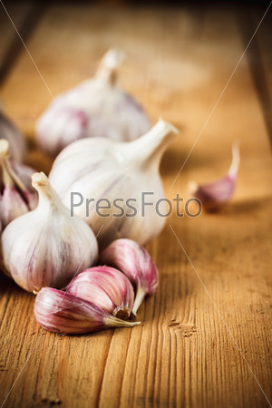 White raw garlic on wooden plank desk background. Organic garlic whole and cloves