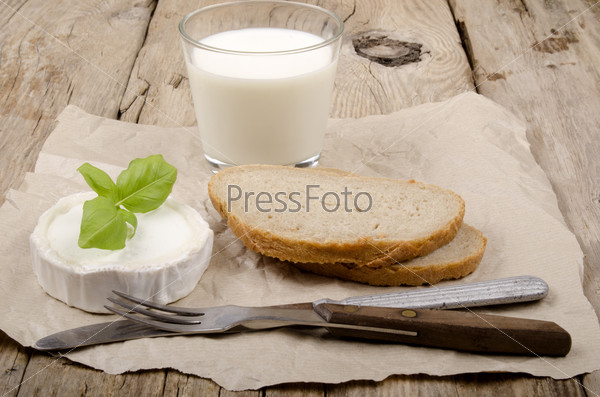 goat cheese, basil,  bread and milk on a country house kitchen table