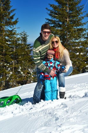Winter season. Happy family having fun on fresh snow on vacation.
