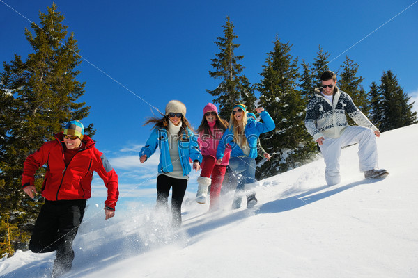 Happy young people group have fun and enjoy fresh snow at beautiful winter day, stock photo