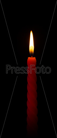 burning wax candle on a black background