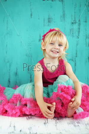 Portrait of cute little princess wearing beautiful tutu skirt on vintage wooden background