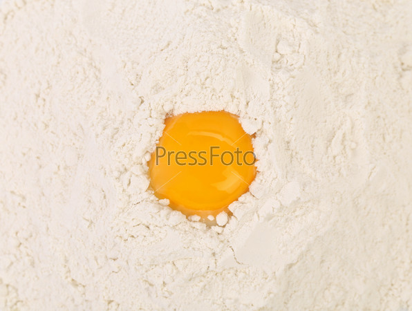 Egg yolk isolated on flour. Whole background, stock photo