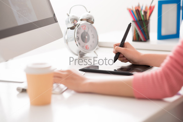 Cropped image of a graphic designer using digital tablet in his work on the foreground