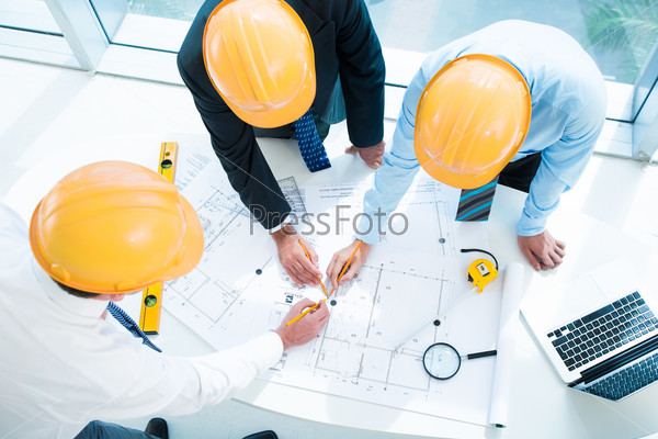 Image of constructor workers sketching together on the foreground viewed below