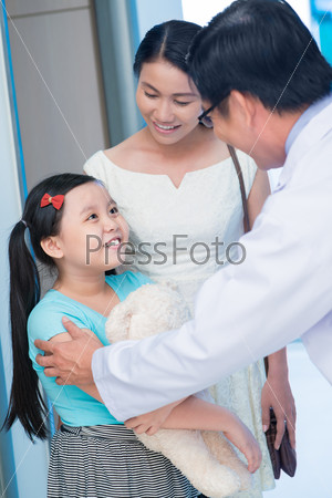 Vertical image of a child at the doctor\'s appointment in the clinic on the foreground