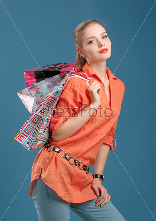 girl in an orange shirt and jeans with shopping bags