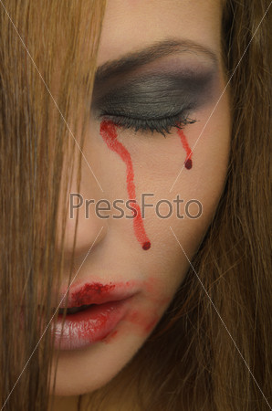 Blood from the eyes and face of woman close up