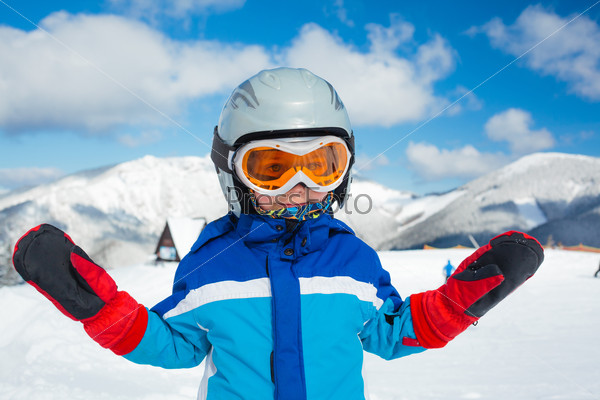 Portrait of little boy studying to ski in ski goggles and a helmet in the mountains