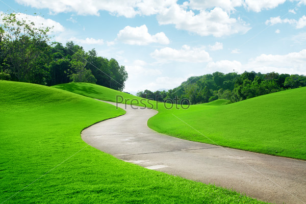 panoramic view of nice green hill and path  on blue sky background